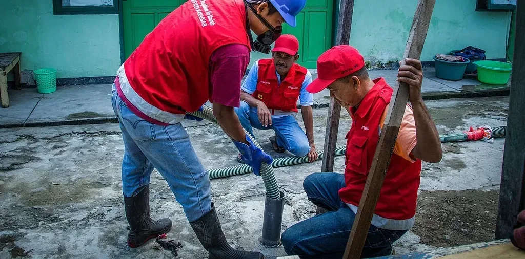 Pekerjaan Jaringan Perpipaan Sistem Pengolahan Air Limbah Komunal Pekerja memasang jaringan perpipaan pada pekerjaan sistem pengolahan air limbah komunal di kawasan permukiman